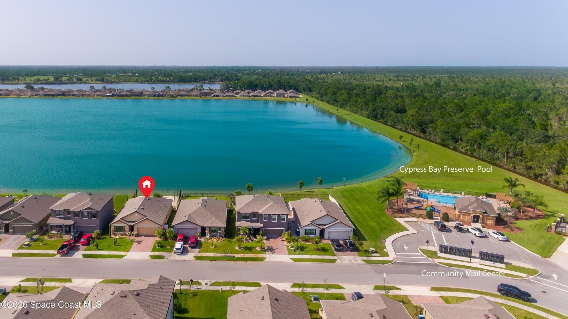 Expansive aerial view showcasing the home’s prime lakefront setting and convenient proximity to the Cypress Bay Preserve community pool.