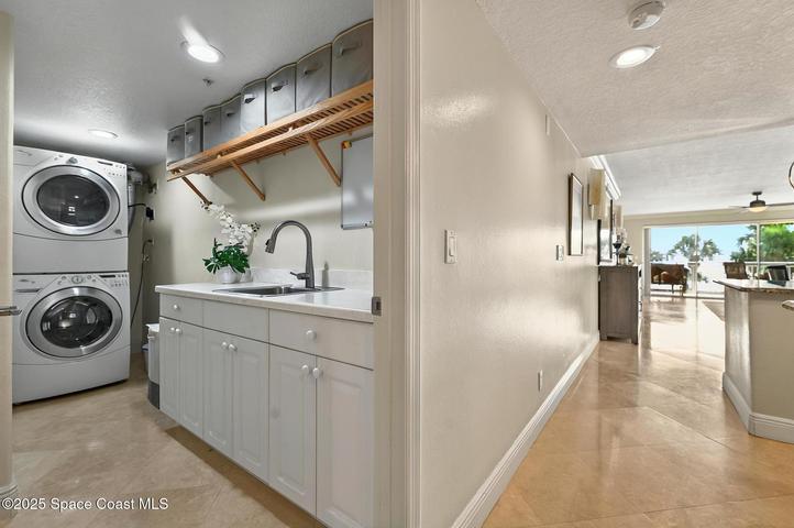 Large utility room with cabinets, storage and sink.