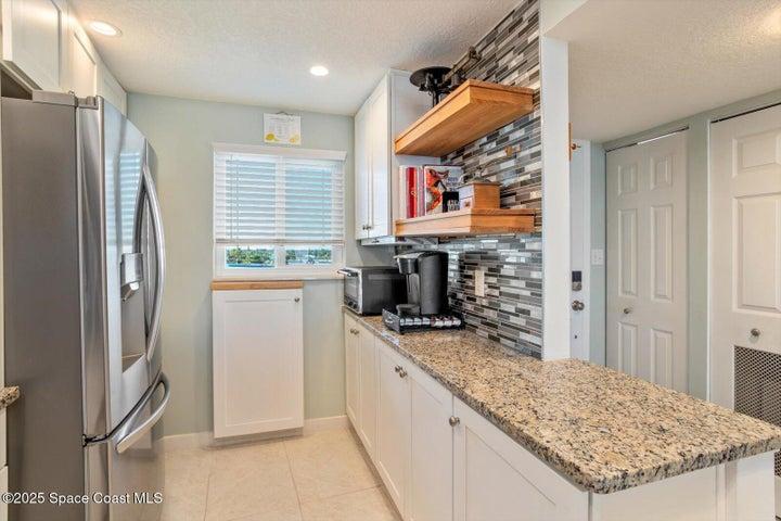 Spacious kitchen with solid surface countertops and stainless appliances.