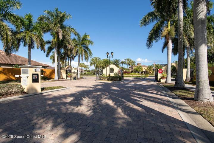 Private gated entrance with palm trees.