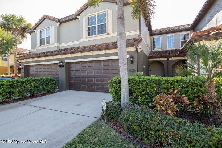 Beautifully maintained townhouse with palm trees.