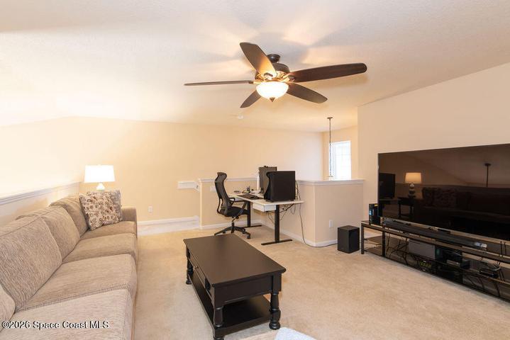 Spacious bonus room with ceiling fan.