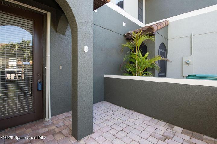 The gated front courtyard offers a secure and stylish transition into the home, perfect for potted plants or a small seating area.