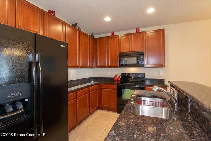 A chef's delight featuring rich wood cabinetry, sleek granite countertops, and a functional layout that overlooks the living area.