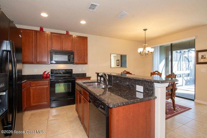 Stunning granite countertops paired with rich wood cabinetry provide a sophisticated look with plenty of storage for the home chef.