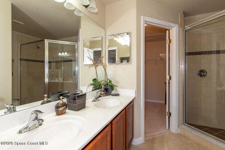 Enjoy a bright, clean aesthetic with a spacious glass-enclosed shower and modern fixtures designed for a peaceful start to your day.