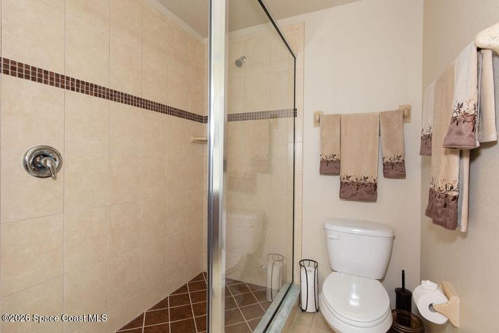 A closer look at the pristine tile work and high-end glass enclosure that give this bathroom a true resort feel.