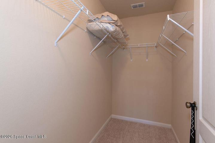 Enjoy the luxury of a dedicated walk-in closet located within the primary suite, offering ample shelving and hanging space to keep your wardrobe organized and accessible.