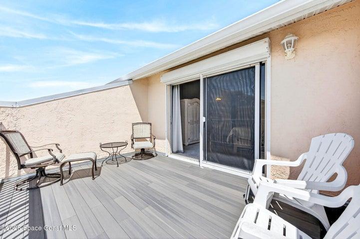 upper level large deck overlooks pool and green area