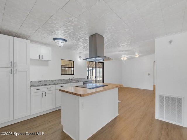 Kitchen featuring butcher block counters, white cabinets, and light wood-type flooring