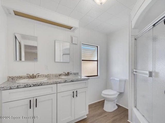 Bathroom featuring double vanity and light wood-type flooring