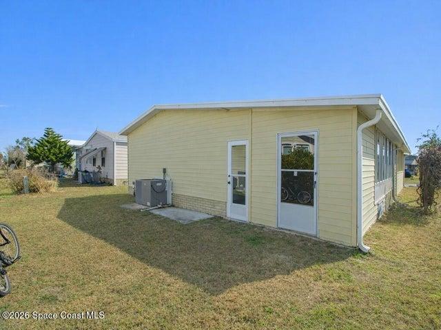 Back of property with a lawn and a patio
