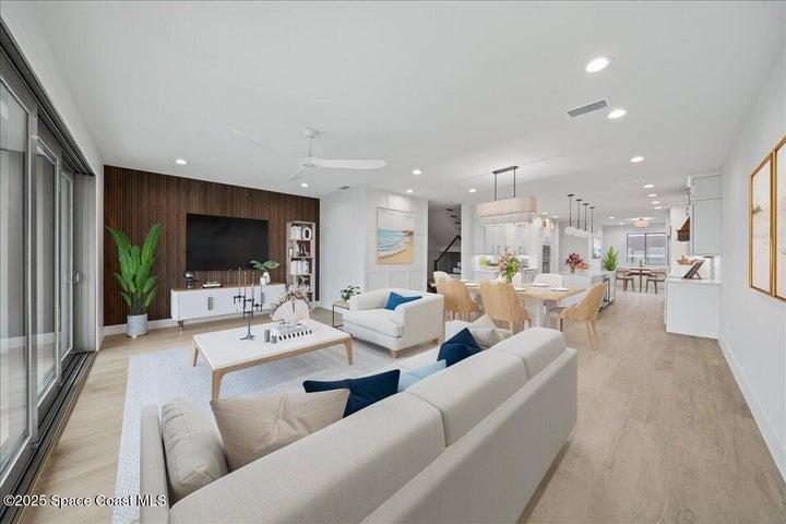 Living area has ocean views, modern accent entertainment wall and flows into dining and kitchen.