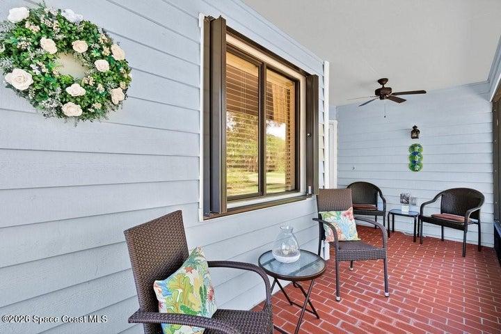 A welcoming covered/screened brick patio leads the way to the front entrance.