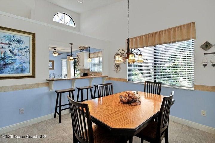 Dining area with vaulted ceilings filled with abundant natural light. Kitchen pass-through/snack bar for additional seating and entertaining.