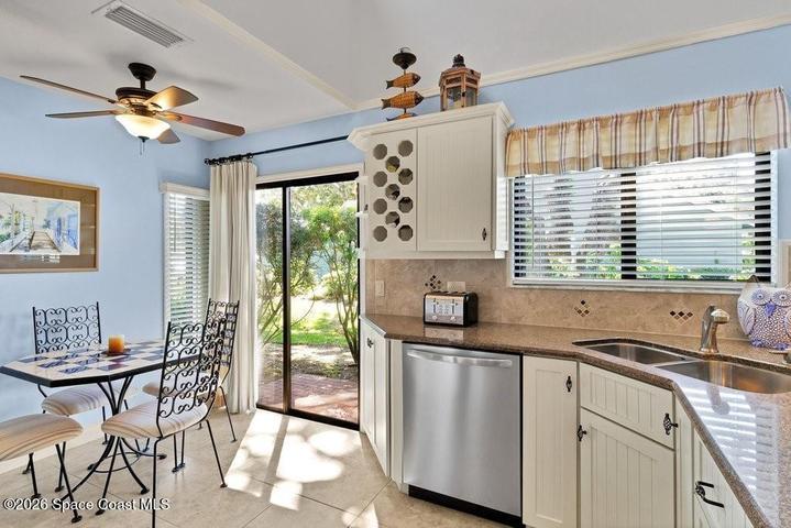 Sunny breakfast nook with sliding glass doors that lead to side brick paver patio/BBQ area.