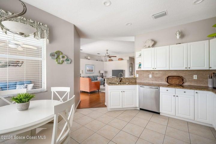 Kitchen featuring white cabinetry, granite countertops, tile flooring, and stainless steel appliances