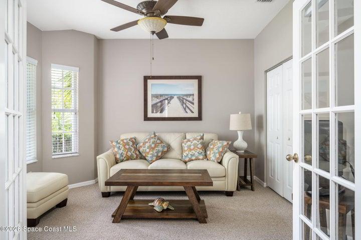 French doors open to a versatile room featuring carpet flooring and neutral wall tones