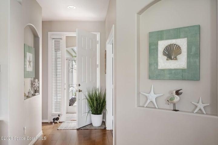 Entryway featuring wood floor finishing, recessed lighting, and a paneled front door with a decorative glass sidelight