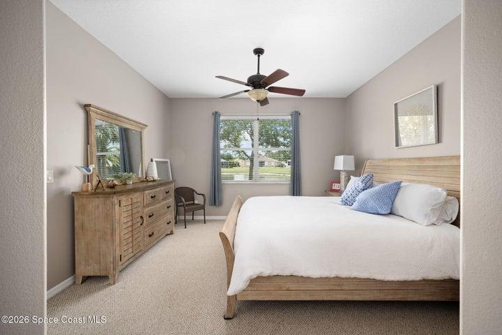Master Bedroom features carpeting, ceiling fan and window facing central pond