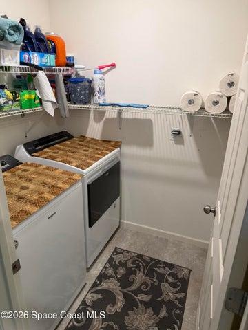 Inside laundry room with storage