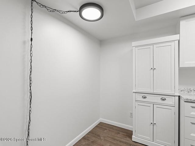 White built-in cabinetry with paneled doors and drawer, complemented by a light granite-style countertop