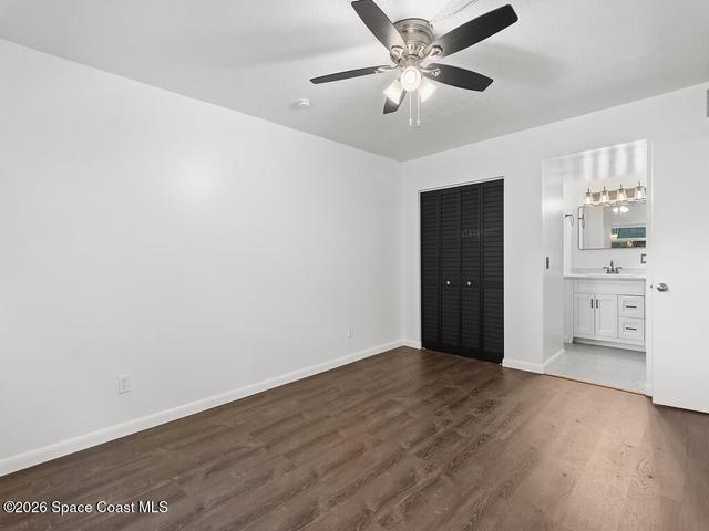 Spacious room featuring wood-finish flooring, a ceiling fan with integrated lighting, and louvered bifold closet doors