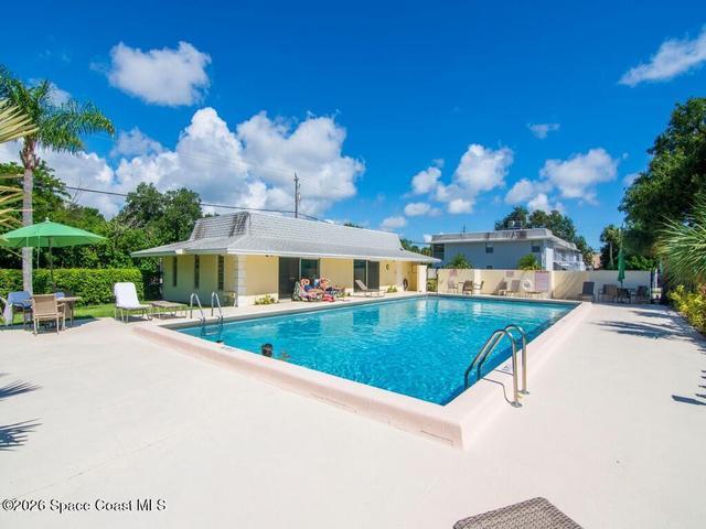 Expansive outdoor swimming pool featuring a perimeter coping, surrounding deck space, and integrated ladder entry