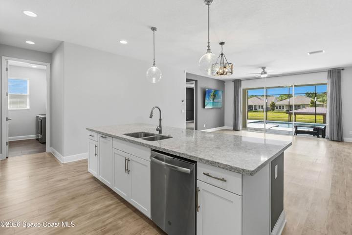 Kitchen flows seamlessly into the dinette and family room, with luxury vinyl flooring. Enjoy the beautiful view of the saltwater, heated pool and canal while cooking a meal.