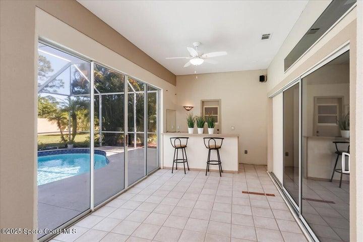 Glass enclosed lanai has wet bar and plenty of room to host a party