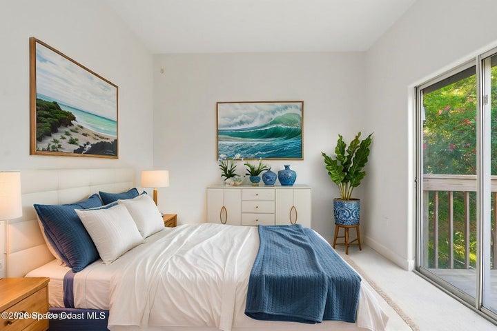 Bedroom #2 with sliders to balcony and peak views of river. Virtually staged