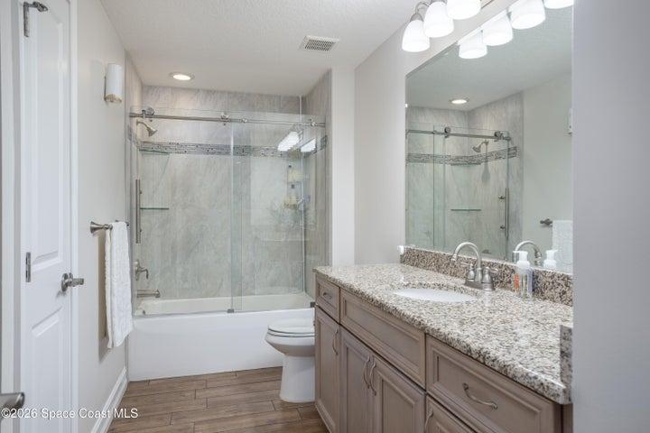 Gorgeous second full bath with new glass enclosure. Custom tile work.