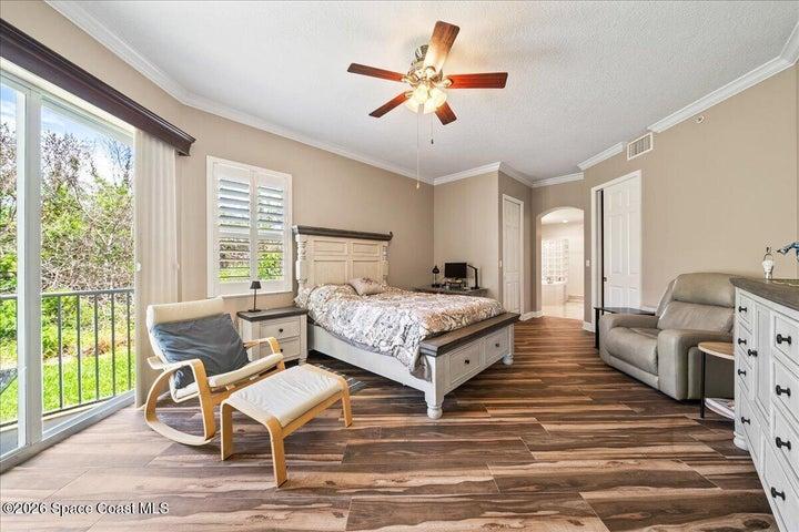 Primary Bedroom with beautiful wood look tile floors accesses the wrap around patio