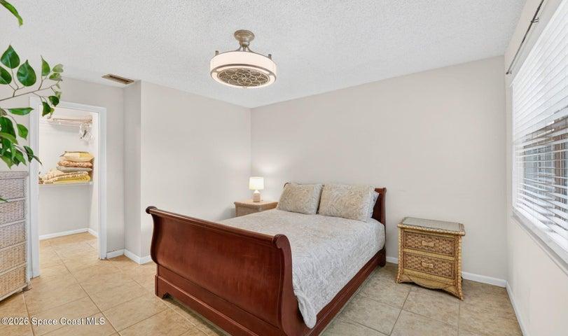Primary bedroom w/tile floors and a walk-in closet
