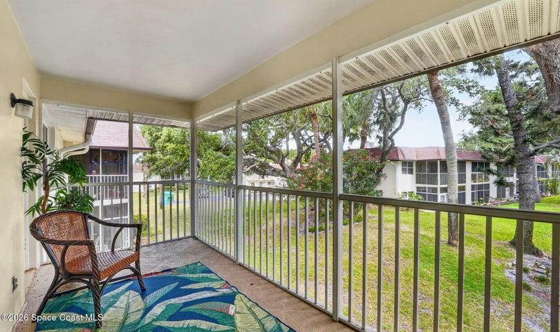 Screened patio overlooking lush trees and greenery.