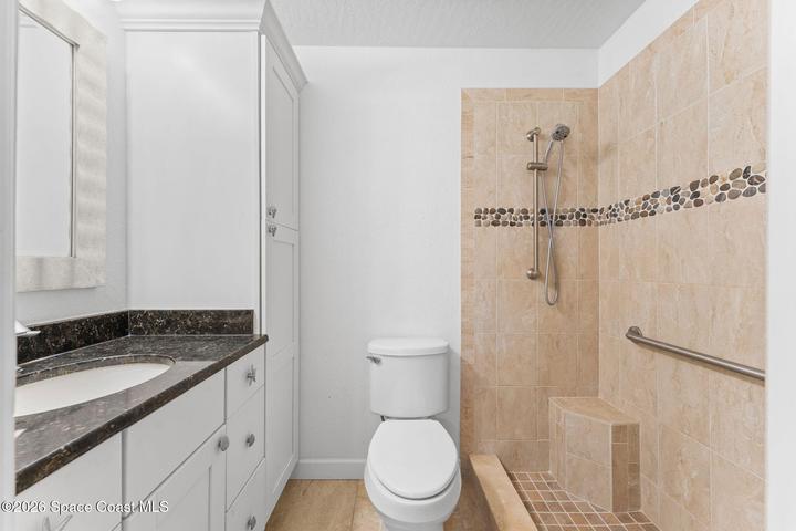 Primary bath with walk-in custom shower and large vanity space and storage