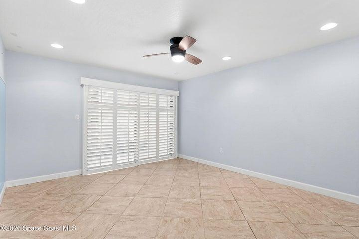 Living room sliders out to the screened patio with plantation shutters
