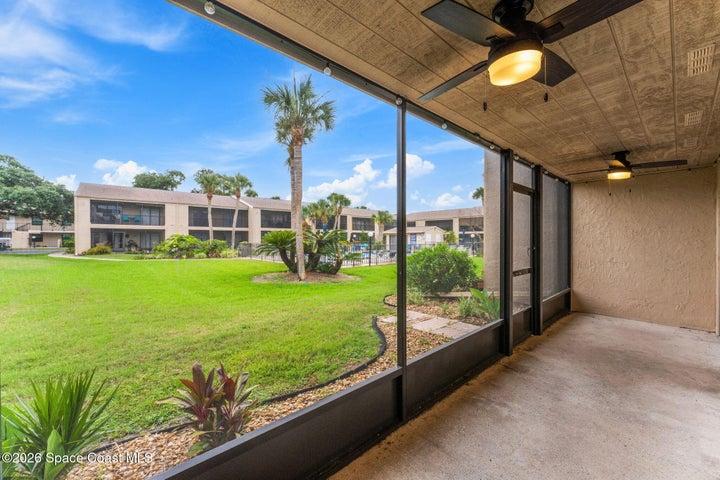Screened patio looking out onto the community courtyard and heated pool
