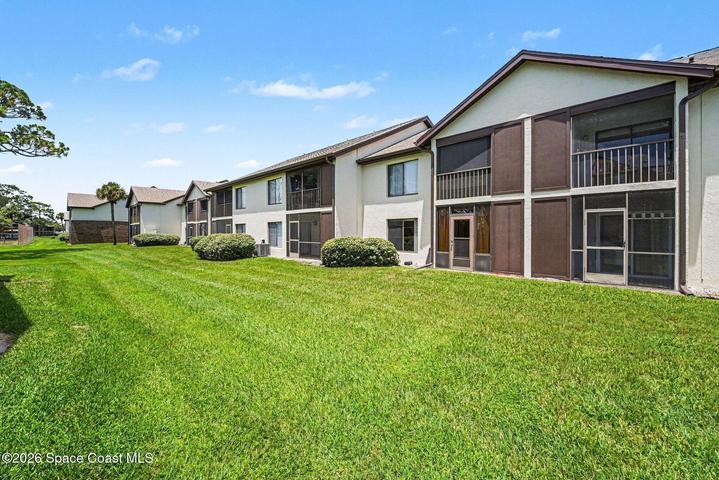 The back of the condo has spacious greenery where you can walk your pet or sit down with a lounge chair to enjoy the Florida sunshine.