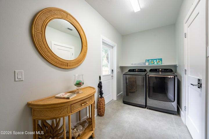 Large indoor laundry and housekeeping area to the right and exit to back yard on left