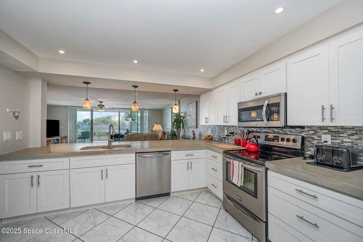 Updated Kitchen with White Soft Close Cabinetry, Polished Concrete Countertops, Dual Sink, Fridgeadare Electic Oven/Range, Dishwasher, Microwave, & Refridgerator/Freezer