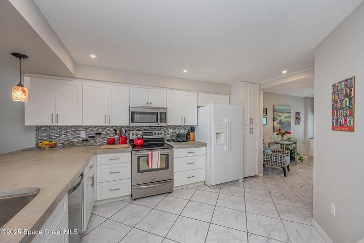 Updated Kitchen with White Soft Close Cabinetry, Polished Concrete Countertops, Dual Sink, Fridgeadare Electic Oven/Range, Dishwasher, Microwave, & Refridgerator/Freezer