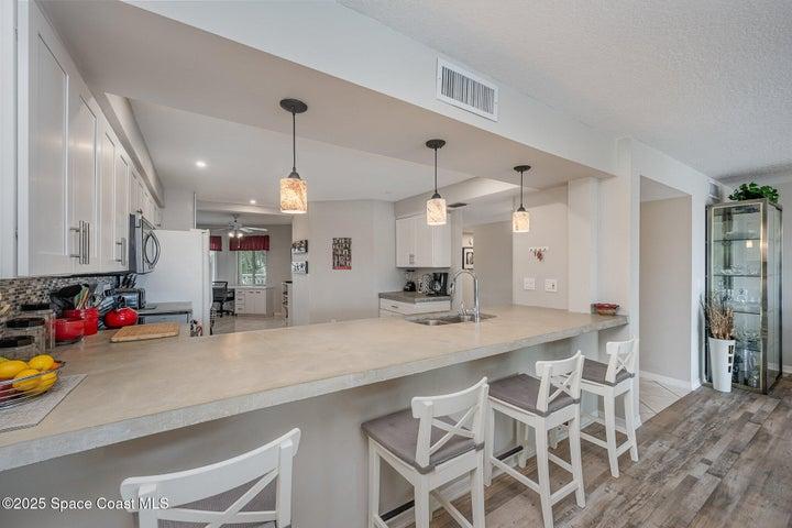 Updated Kitchen with White Soft Close Cabinetry, Polished Concrete Countertops, Dual Sink, Fridgeadare Electic Oven/Range, Dishwasher, Microwave, & Refridgerator/Freezer