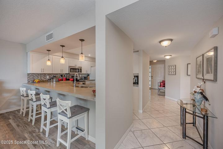 Updated Kitchen with White Soft Close Cabinetry, Polished Concrete Countertops, Dual Sink, Fridgeadare Electic Oven/Range, Dishwasher, Microwave, & Refridgerator/Freezer