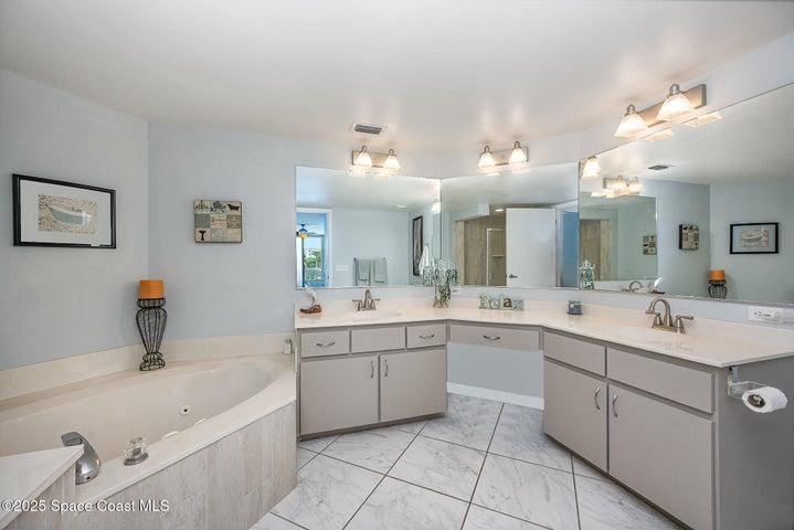 Spacious Primary Bedroom with Walk-in Dual Closets, Slider to Balcony, & En-Suite Bathroom with Dual Sinks, Walk-In Shower, & Separate Soaking Tub.