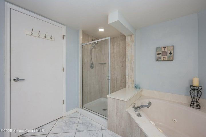 Spacious Primary Bedroom with Walk-in Dual Closets, Slider to Balcony, & En-Suite Bathroom with Dual Sinks, Walk-In Shower, & Separate Soaking Tub.