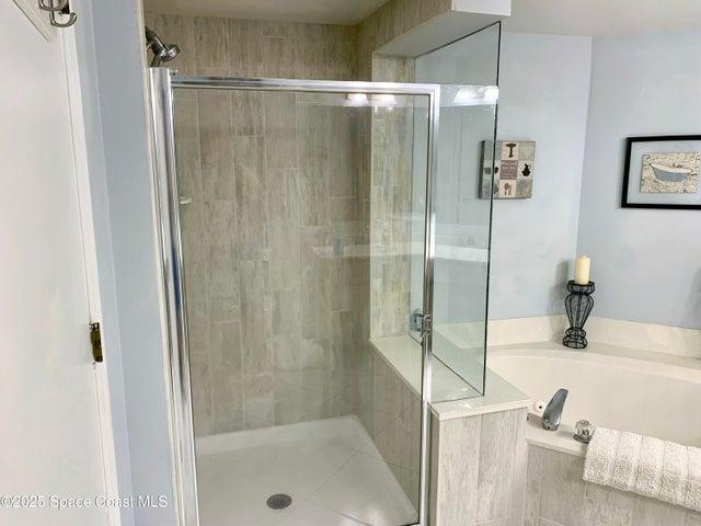 Spacious Primary Bedroom with Walk-in Dual Closets, Slider to Balcony, & En-Suite Bathroom with Dual Sinks, Walk-In Shower, & Separate Soaking Tub.