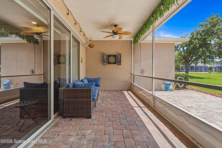 Trussed, screened patio with pavers.