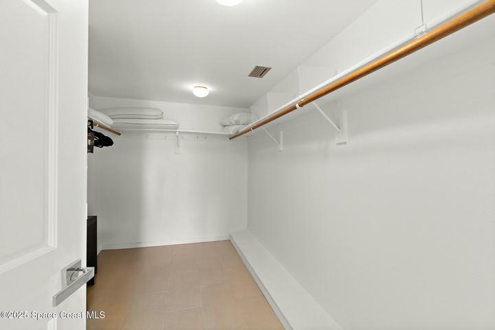 Walk-in closet with hanging rods and built-in shelving, Riverwest condo, Cocoa Beach, Florida