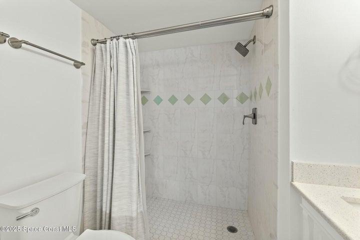 Primary bathroom walk-in tile shower with decorative accent tile, Riverwest condo, Cocoa Beach